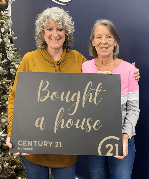 Holding a sing to show she bought a house in Clermont FL